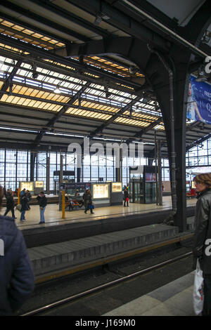 La gente camminare e in attesa per il treno sulla piattaforma a Friedrichstrasse stazione ferroviaria a Berlino Germania Foto Stock