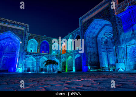 Colorato luminoso atrio di Sher-Dor Madrasah di notte, Samarcanda Registan, Uzbekistan Foto Stock