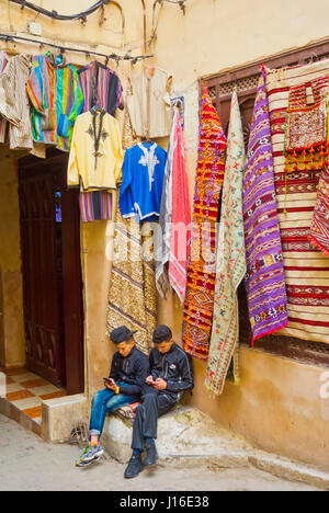 Ragazzi utilizzando gli smartphone, Rue Talaa Seghira, Fes el-Bali, la Medina di Fez, Marocco, Africa Foto Stock