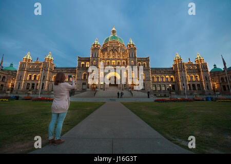 Una donna di scattare una foto del Palazzo del Parlamento in Victoria, British Columbia, Canada Foto Stock