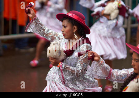 Llamerada ballerini in costumi ornati di eseguire come sfilano attraverso la città mineraria di Oruro sull'altipiano della Bolivia durante il carnevale annuale Foto Stock