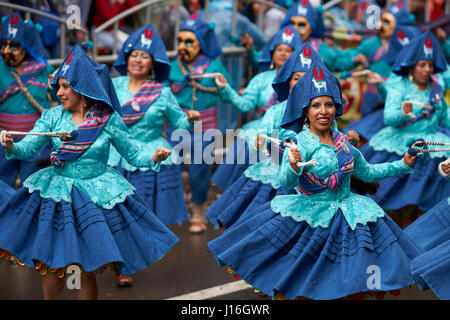 Llamerada ballerini in costumi ornati di eseguire come sfilano attraverso la città mineraria di Oruro sull'altipiano della Bolivia durante il carnevale annuale Foto Stock