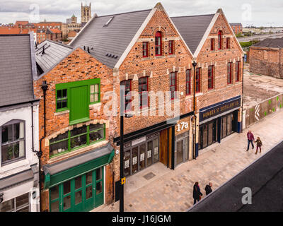 Humber Street, il mercato della frutta di rigenerazione urbana nella zona dello scafo area dock con chiesa della Santa Trinità di clock tower in distanza, Hull, Regno Unito. Foto Stock