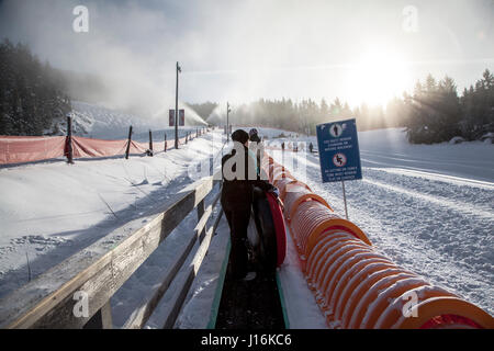 La gente che ottiene pronta per scivolare sulla neve i tubi , Whistler Foto Stock