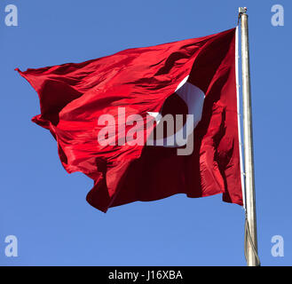 Bandiera turca sul pennone sventolare nel vento in un cielo blu Foto Stock