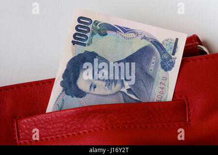 Yen giapponese in un rosso borsa in pelle. Foto Stock