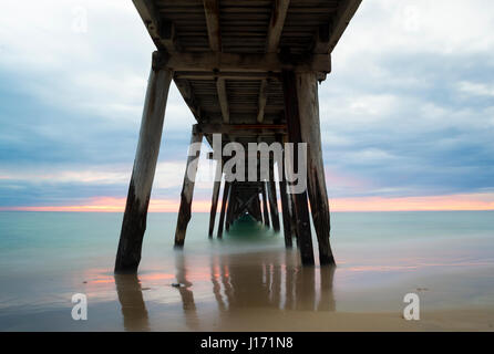 Pastel tramonto visto da sotto il Port Noarlunga jetty, in costiera esterna sobborghi di Adelaide, Australia del Sud. Molto lenta velocità otturatore utilizzato compiendo Foto Stock