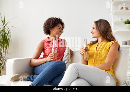 Felici donne con birra parlando a casa Foto Stock