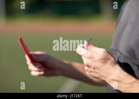 Arbitro mani con carta rossa sul campo di calcio Foto Stock