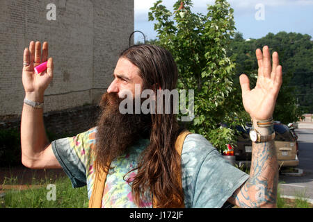 Uomo con capelli lunghi e barba sulla strada Foto Stock