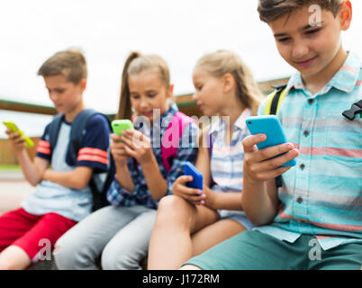 Gli studenti della scuola elementare con gli smartphone Foto Stock