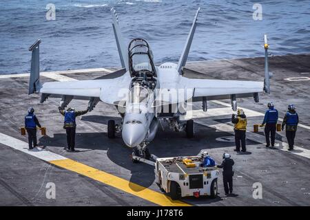 Uss Theodore Roosevelt, Stati Uniti d'America. Xvii Apr, 2017. Stati Uniti I marinai della marina park un F/A-18F Super Hornet Fighter Aircraft, assegnato all'Redcocks di Strike Fighter Squadron di attacco 22, sul ponte di volo a bordo della Nimitz-class portaerei USS Theodore Roosevelt 17 aprile 2017 nell'Oceano Pacifico. La portaerei è in corso di addestramento al largo della costa della California del Sud. Credito: Planetpix/Alamy Live News Foto Stock