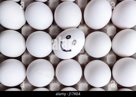 Bianco e un sorriso le uova in una scatola di cartone. Vista superiore Foto Stock
