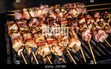 Grigliare gli spiedini di carne sul carbone naturale barbecue grill. La preparazione di un grande bistecca su naturale barbecue a legna nel caminetto esterno. Foto Stock