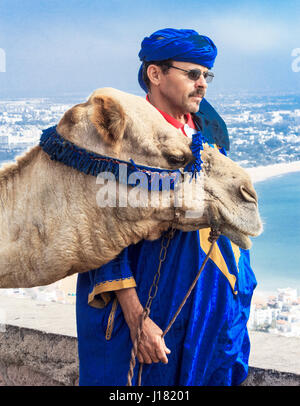 Driver di cammello sulla montagna di fronte alla baia di Agadir, Marocco, Africa Foto Stock