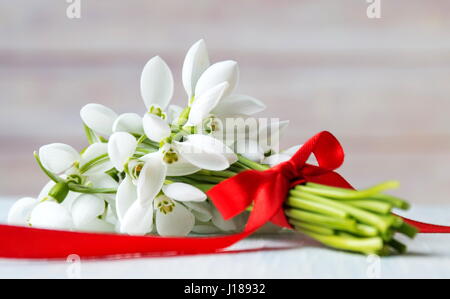 Snowdrops fresco bouquet su uno sfondo di legno Foto Stock