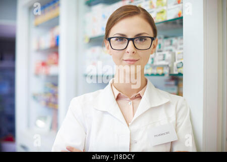 Giovane farmacista in piedi in drug store Foto Stock