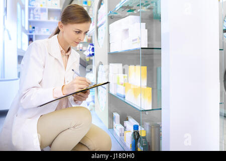Fiducioso il farmacista facendo un inventario presso drug store Foto Stock