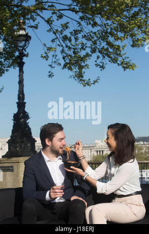 Solo uso editoriale londinesi Charlie Smith, 26 e Lisa Adu, 25, godetevi una cena data dopo un tutorial virtuale con Michele Liquori di Milano, in Italia, in occasione del lancio di 'Milan Upon Thames', che è stato creato da Deliveroo in partnership con tre mobile app rewards Wuntu, sul London South Bank. Foto Stock