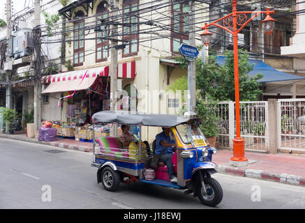 Un tuk tuk con passeggero rende modo lungo una strada a Chinatown, Bangkok, Thailandia Foto Stock
