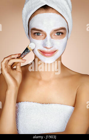 Giovane donna applicando idratante maschera facciale. Foto di Pretty Woman riceve i trattamenti della spa. Beauty & Skin care concept Foto Stock