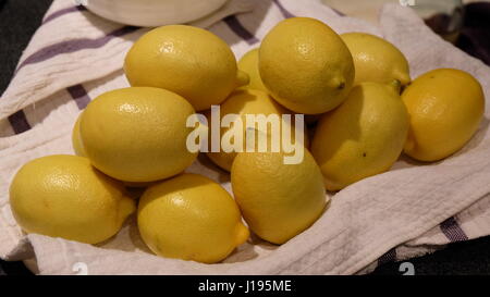 Limoni freschi impilati nella parte superiore di un pezzo di stoffa Foto Stock