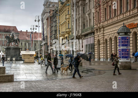 Zagabria, Croazia - passeggini che passano per la piazza Ban Jelacic sotto la pioggia Foto Stock