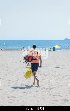 Bay watcher è andare al posto di osservazione con la bandiera gialla. Mattina di sole sulla spiaggia di Castellon de la Plana, a Valencia (Spagna) Foto Stock