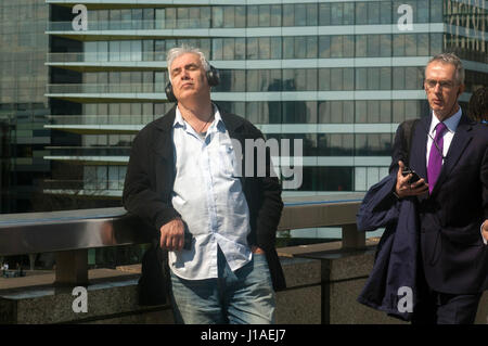 Londra, UK, 19 aprile 2017, un " commuter " passa un uomo godendo il sole e la sua musica. Blu brillante cieli soleggiati su London Bridge nel pomeriggio. Credito: JOHNNY ARMSTEAD/Alamy Live News Foto Stock