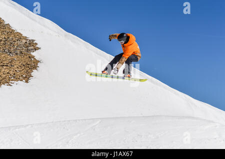 MADONNA DI CAMPIGLIO (TN), Italia, Aprile 8, 2017. Snowboarder godendo corre e salta sulla molla dell ultima neve. Foto Stock