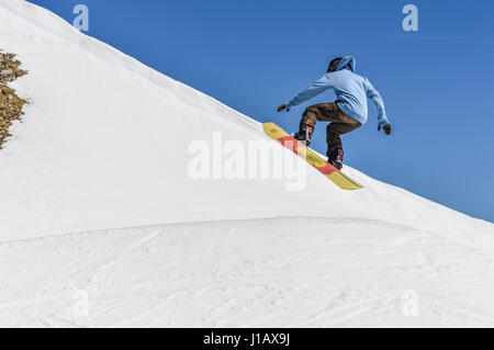 MADONNA DI CAMPIGLIO (TN), Italia, Aprile 8, 2017. Snowboarder godendo corre e salta sulla molla dell ultima neve. Foto Stock