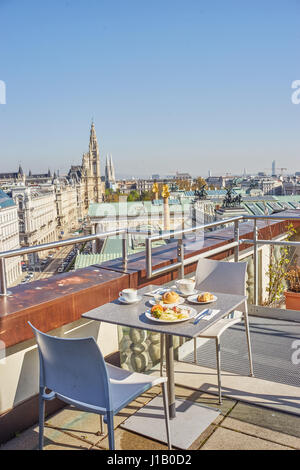 Balcone con tavolino servito per due sullo sfondo della città di Vienna in Austria. Colpo verticale. Foto Stock