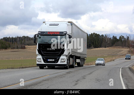 Salo, Finlandia - 13 aprile 2017: bianco Iveco Stralis hi-modo semi carrello cale curtainsider tra rimorchio il traffico di una giornata nuvolosa della molla. Foto Stock