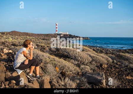 Caucasian donna seduta sulle rocce a ocean Foto Stock