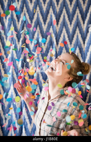 Donna felice di festeggiare con coriandoli Foto Stock