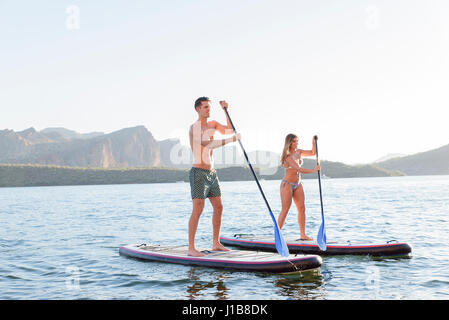 Matura in piedi sul paddleboards nel fiume Foto Stock