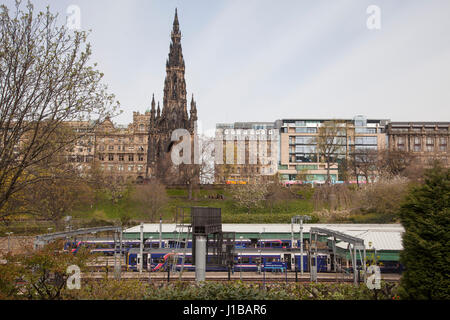 Vista la stazione ferroviaria di Waverly in Princess Gardens, Edimburgo, Scozia, Regno Unito. Passo passo le persone dentro e fuori del treno. Monumento di Scott in background. Foto Stock