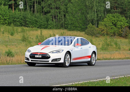 PAIMIO, Finlandia - 24 luglio 2016: il bianco e il rosso Tesla Model S Design unico veicolo elettrico si sposta lungo la green strada rurale nel sud della Finlandia in estate Foto Stock