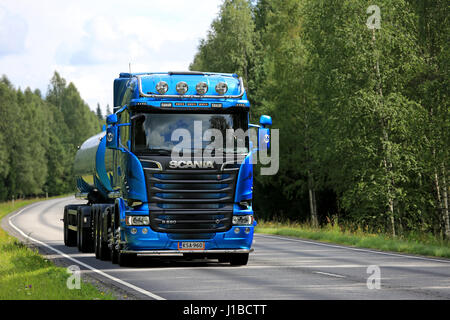 TENHOLA, Finlandia - 30 luglio 2016: Blu Scania R580 autobotte sulla autostrada rurale affiancata da foresta verde in estate. Foto Stock