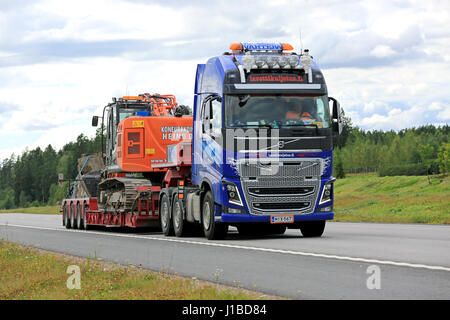 PAIMIO, Finlandia - 31 luglio 2016: Volvo FH16 600 cale Hitachi escavatore cingolato sul rimorchio Noteboom lungo la superstrada nel sud della Finlandia. Foto Stock