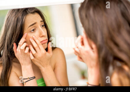 Donna con acne in bagno Foto Stock