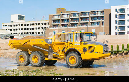 Volvo A25E articolata del trasportatore (camion) spostando shingle su Worthing Beach, Worthing, West Sussex, in Inghilterra, Regno Unito. Foto Stock