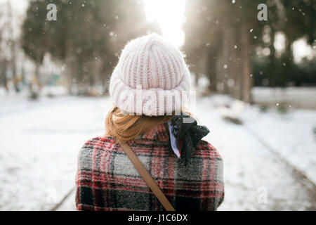 Vista posteriore della donna caucasica all'aperto nella neve Foto Stock
