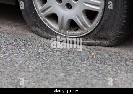 Il pneumatico sgonfio sulla strada Foto Stock