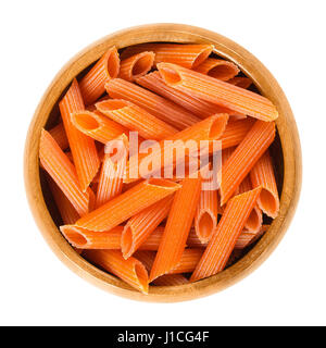 Di lenticchie rosse penne la pasta nella ciotola di legno. Non cotti essiccato senza glutine tagliatelle. Lens culinaris. A breve il taglio di media lunghezza tubi con creste tagliati diagonalmente. Foto Stock