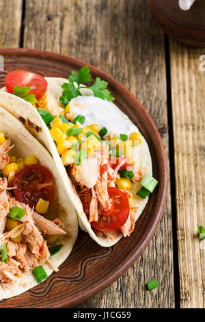 In casa slow cooker chicken taco con mais servita su rustiche piastra ceramica sul tavolo in legno, stile messicano Foto Stock