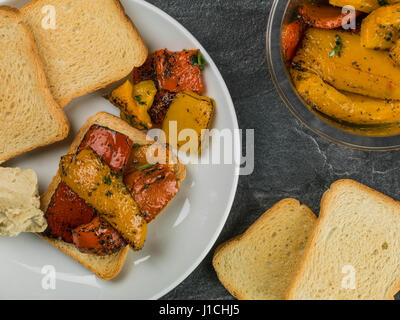 Peperoni cotti su toast francesi contro uno sfondo nero Foto Stock