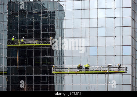 Operai su una piattaforma la riparazione di vetro frontale in costruzione Foto Stock