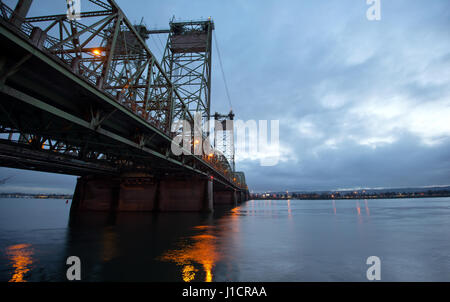 Sollevamento traliccio metallico ponte sopra il fiume Colombia su calcestruzzo Piloni su cui passa la automotive autostrada Interstate 1-5, con la riflessione della luce Foto Stock