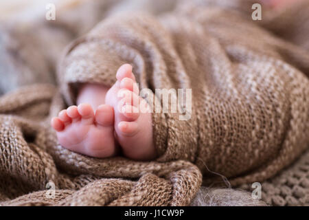 In prossimità dei piedi del neonato avvolto in una coperta. Macro shot, profondità di campo. Foto Stock